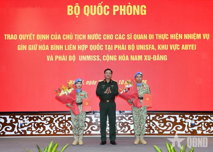  Thượng tướng Nguyễn Trường Thắng trao Quyết định của Chủ tịch nước cho hai đồng chí sĩ quan. Ảnh: TUẤN HUY