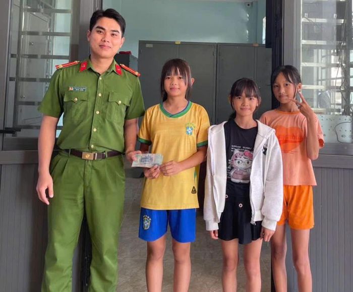 3 em học sinh mang số tiền nhặt được giao nộp cho Công an xã.