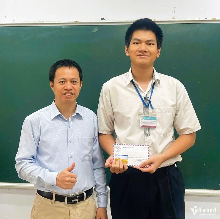 Nguyễn Xuân Toàn được thầy giáo chủ nhiệm lớp 12A1, trường THPT Đoàn Kết - Hai Bà Trưng, khen thưởng sau khi giành giải Nhất và là thủ khoa kỳ thi chọn học sinh giỏi TP. Hà Nội năm 2026. Ảnh: NVCC.