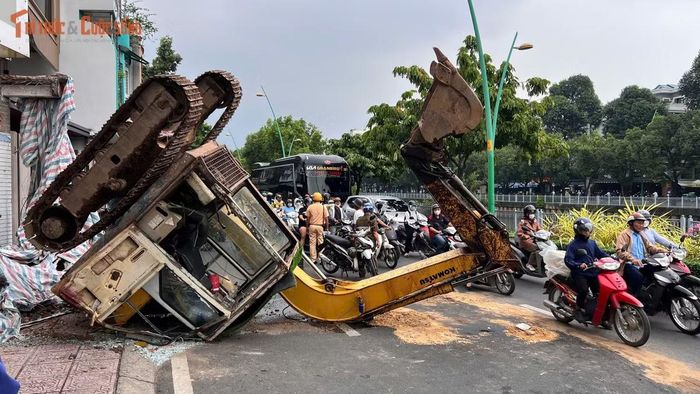 May mắn không có ai bị thương khi máy múc lật ra đường.