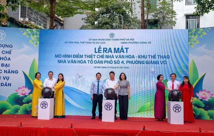 Đại biểu thực hiện nghi thức ra mắt mô hình điểm thiết chế văn hóa tổ dân phố và mô hình "Nhà văn hóa số" tại Nhà văn hóa Tổ dân phố số 4, phường Giảng Võ. Ảnh: TT.