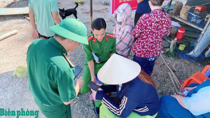 Cán bộ Đồn Biên phòng Hòn Chuối phối hợp cùng Công an xã Sông Đốc hỗ trợ người dân cài đặt và sử dụng ứng dụng VNeID. Ảnh: Hoàng Tá