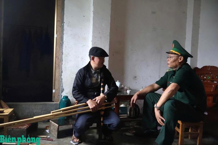 Cán bộ Đồn Biên phòng Lũng Cú trao đổi với anh Sùng Mí Nhù, thôn Tả Giao Khâu, xã Lũng Cú về việc sử dụng nền tảng mạng xã hội để livestream biểu diễn Khèn Mông tạo tiền đề lan tỏa giá trị truyền thống và các sản phẩm địa phương. Ảnh: Văn Thành