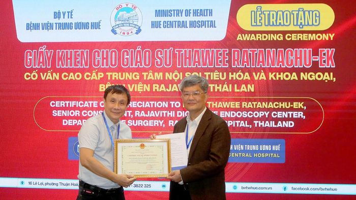 Lãnh đạo BVTW Huế trao giấy khen cho Giáo sư Thawee Ratanachu- Ek, Cố vấn cao cấp Trung tâm Nội soi tiêu hóa và khoa ngoại, Bệnh viện Rajavithi (Thái Lan). (Ảnh: B.Trâm)