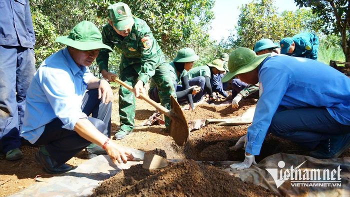 Cán bộ, chiến sĩ Đội K52 tìm kiếm, quy tập hài cốt liệt sĩ tại vườn điều của gia đình già Siu Pích. Ảnh: Ngọc Thu