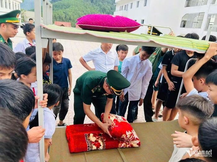  Cán bộ Đồn Biên phòng Yên Khương hướng dẫn học sinh gấp chăn màn. 