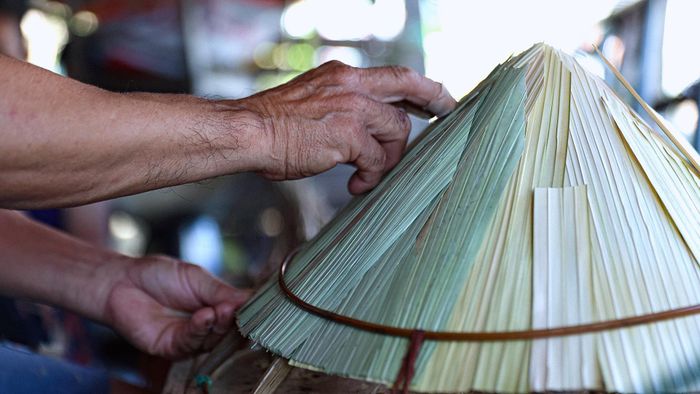  Chiếc nón được tôi lợp bằng nhiều lớp lá, xếp chồng lên nhau để tăng độ dày và độ bền. Lớp lá bên ngoài phải phẳng, đều, còn lớp bên trong được sắp xếp kín khít, giúp nón chắc chắn nhưng vẫn giữ được vẻ thanh thoát. 