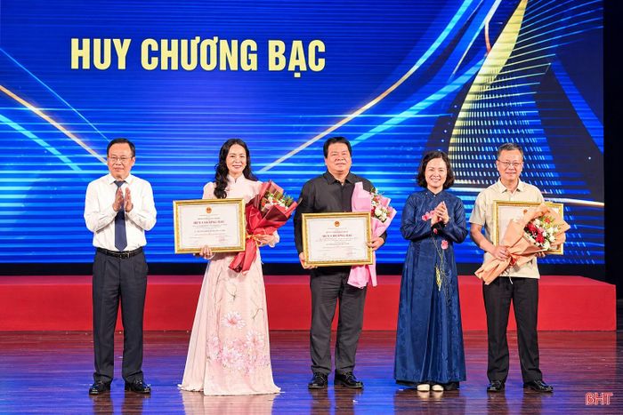 Ông Nguyễn Tiến Chương (ngoài cùng bên phải) - Phó Giám đốc Nhà hát Nghệ thuật truyền thống Hà Tĩnh nhận HCB cho hạng mục giải toàn đoàn.