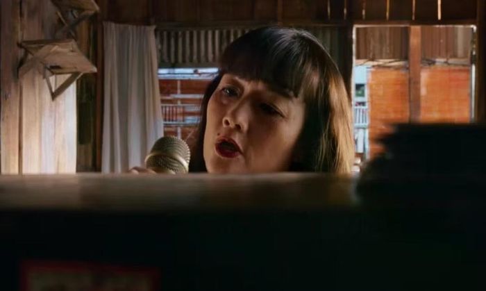 Vân Dung vào vai nạn nhân bị sát hại bằng micro trong "Án mạng karaoke." (Ảnh từ phim)