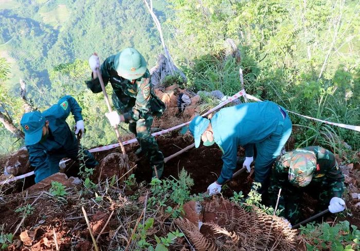 Lãnh đạo Bộ Chỉ huy Quân sự tỉnh; cấp ủy, chính quyền địa phương và cán bộ, chiến sỹ Đội Tìm kiếm, quy tập hài cốt liệt sỹ vượt địa hình đồi núi, đưa hài cốt liệt sỹ ra khỏi khu vực tìm kiếm. (Ảnh: Vietnam+)