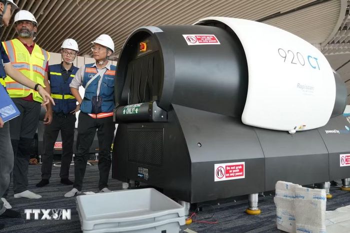 Chuyên gia nước ngoài trao đổi với người lao động Việt Nam trong quá trình lắp đặt máy soi chiếu hành lý xách tay 3D tại sân bay Long Thành. (Ảnh: Công Phong/TTXVN)