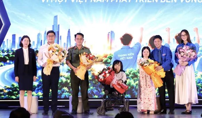 Ban tổ chức tặng hoa cho các diễn giả chia sẻ tại tọa đàm. (Ảnh: Vietnam+)