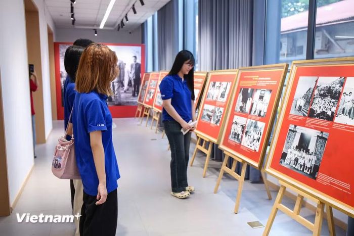 Các bạn trẻ được tham quan triển lãm ảnh về quan hệ Việt Nam-Trung Quốc và hoạt động cách mạng của Chủ tịch Hồ Chí Minh tại Trung Quốc. (Ảnh: Trịnh Ngọc/Vietnam+)
