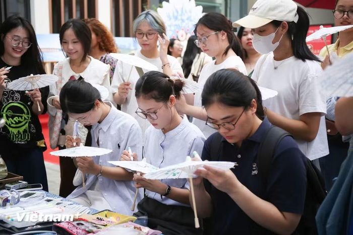 Chương trình gồm nhiều hoạt động như thưởng trà, tô màu “Thỏ gia,” trải nghiệm in rập “Phúc vận,” làm hoa nhung Kinh kịch, làm dấu trang thổ cẩm Choang, làm phụ kiện tóc bằng thổ cẩm Choang, vẽ tay trên ô giấy dầu, trải nghiệm đan tre, cắt giấy là các Di sản văn hóa phi vật thể của địa phương. (Ảnh: Trịnh Ngọc/Vietnam+)