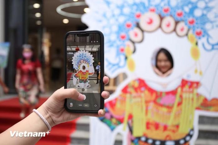 Các bạn trẻ thích thú chụp ảnh check-in tại sự kiện. (Ảnh: Trịnh Ngọc/Vietnam+)