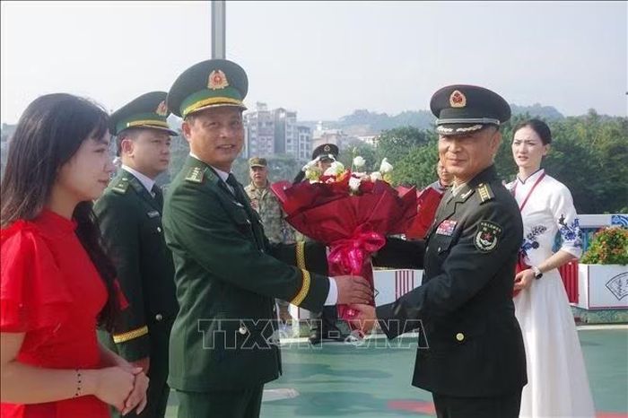 Đại tá Kiều Phi Hùng, Tham mưu trưởng Bộ đội Biên phòng tỉnh Lào Cai tặng hoa chào mừng Đại tá Đồng Quân Long, Chính ủy Bộ đội Biên phòng khu Mông Tự sang tham dự hội đàm. Ảnh: TTXVN phát
