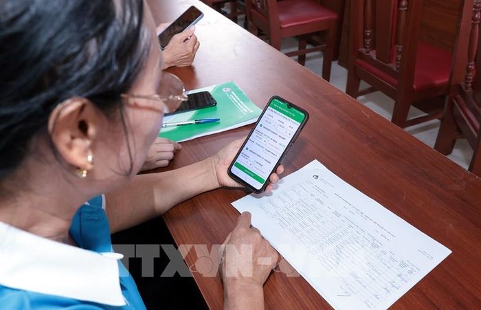 Tổ trưởng tổ tiết kiệm và vay vốn rà soát hộ hay trên ứng dụng VBSP SmartBanking. Ảnh: Trần Việt – TTXVN