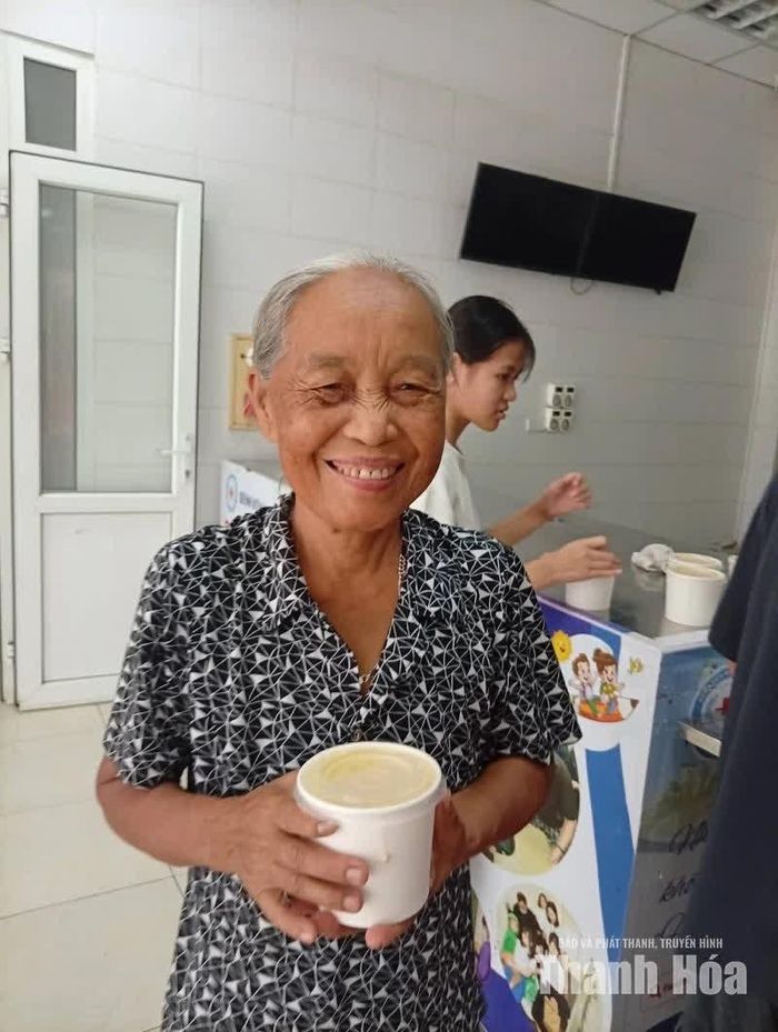 Niềm vui của người nhà bệnh nhân khi được nhận suất cháo miễn phí còn ấm nóng.