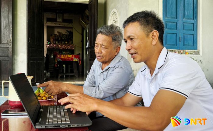 Ông Đoàn Công Lâm (bên phải), Bí thư Chi bộ thôn Bình Yên hỗ trợ ông Lê Bốn cập nhật hồ sơ lên hệ thống điện tử. Ảnh: PHAN VINH