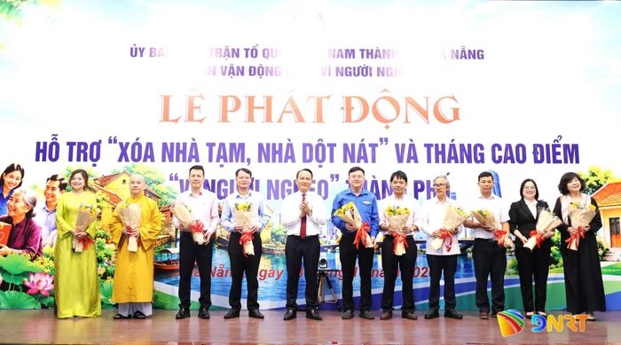 Phó Bí thư Thành ủy, Chủ tịch Ủy ban MTTQ Việt Nam thành phố Nguyễn Đình Vĩnh (thứ 5 từ trái sang) tặng hoa cảm ơn các doanh nghiệp, tổ chức, cơ quan ủng hộ chương trình “Xóa nhà tạm, nhà dột nát” và Tháng cao điểm “Vì người nghèo”. Ảnh: NGỌC HÀ