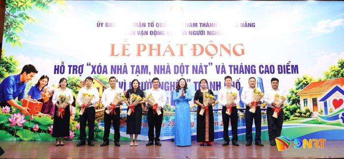 Phó Chủ tịch Thường trực Ủy ban MTTQ Việt Nam thành phố Nguyễn Thị Thu Lan (thứ 5 từ phải sang) tặng hoa cảm ơn các doanh nghiệp, tổ chức, cơ quan ủng hộ chương trình “Xóa nhà tạm, nhà dột nát” và Tháng cao điểm “Vì người nghèo”. Ảnh: NGỌC HÀ