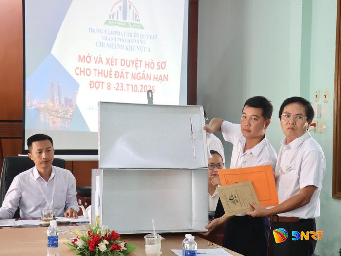 Đại diện Chi nhánh khu vực 8 - Trung tâm Phát triển quỹ đất thành phố Đà Nẵng thực hiện quy trình mở hồ sơ, xét duyệt theo quy định. Ảnh: QUỐC TUẤN