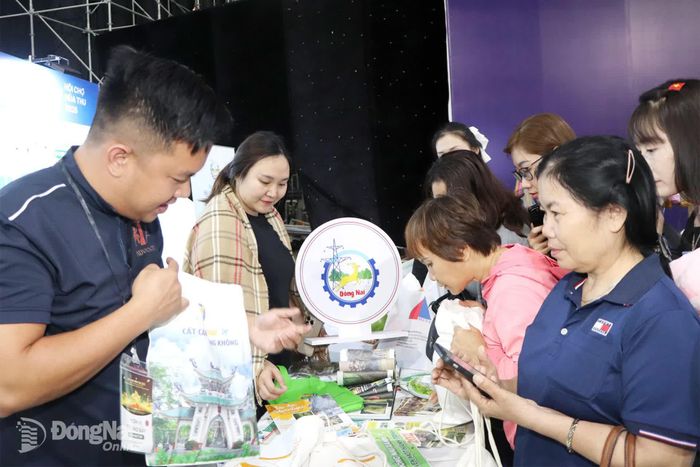 Trung tâm Xúc tiến đầu tư, thương mại và du lịch thành phố tặng quà là chiếc túi vải có in hình Văn miếu Trấn Biên cho du khách tại Hội chợ mùa thu Hà Nội năm 2025.