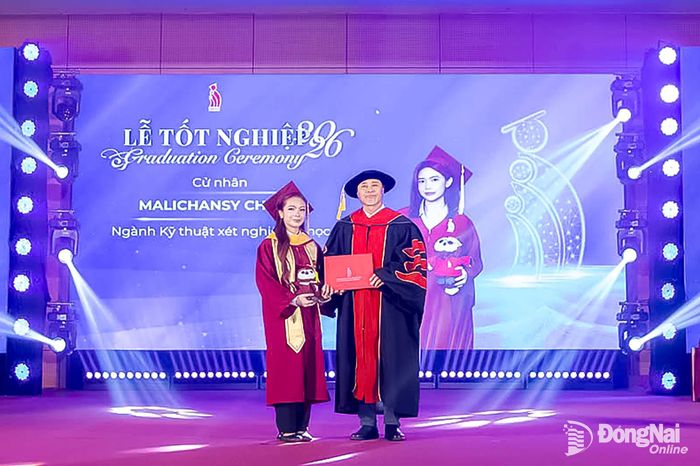 Tiến sĩ Phan Ngọc Sơn, Hiệu trưởng Trường đại học Công nghệ Đồng Nai trao bằng tốt nghiệp cho cử nhân Malichansy Chinny. Ảnh: Công Nghĩa