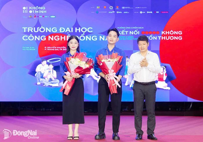 Phó Giám đốc Sở Giáo dục và Đào tạo Đỗ Đăng Bảo Linh tặng hoa cho các thành viên xung kích trên mặt trận tuyên truyền phòng, chống lừa đảo trên không gian mạng trong ngày ra mắt. Ảnh: Công Nghĩa