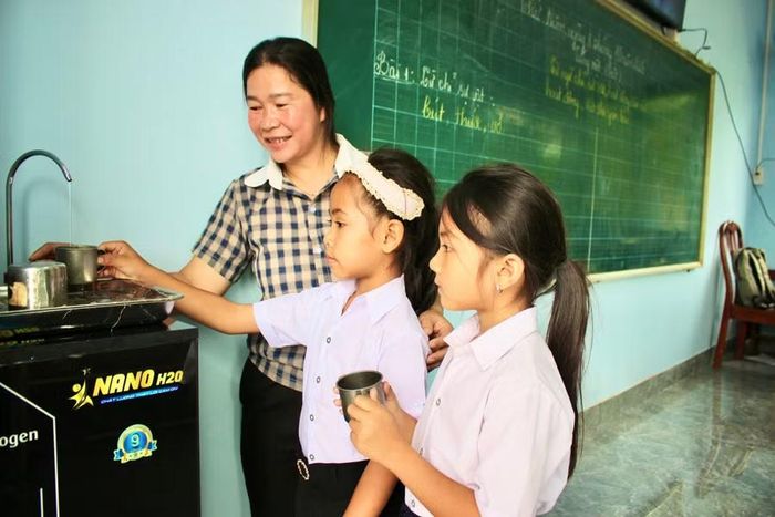  Giáo viên hướng dẫn học sinh sử dụng máy lọc nước tại điểm trường làng Rỏih. Ảnh: Minh Chí 