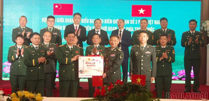 Đại tá Nguyễn Phi Khanh (phía trước, bên trái) và Đại tá Đồng Quân Long (phía trước, bên phải) trao tặng quà lưu niệm tại hội đàm.