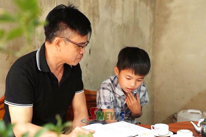 Ông Đinh Minh Suất dạy cháu nhỏ hát Đang Mường.