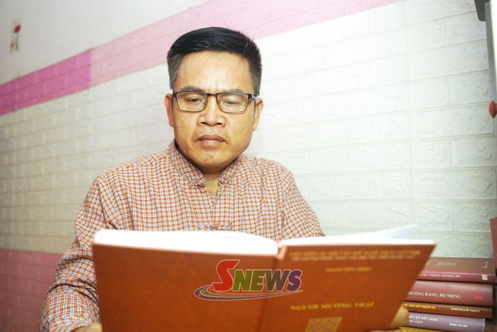 Ông Đinh Minh Suất nghiên cứu sách về văn hóa dân tộc Mường.
