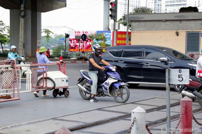 Nhiều tài xế xe máy cố vượt cảnh báo đường sắt.