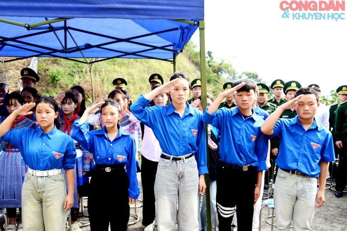 Đoàn viên thanh niên chào cờ Tổ quốc ngay cột mốc biên giới. Ảnh: Quốc Hồng