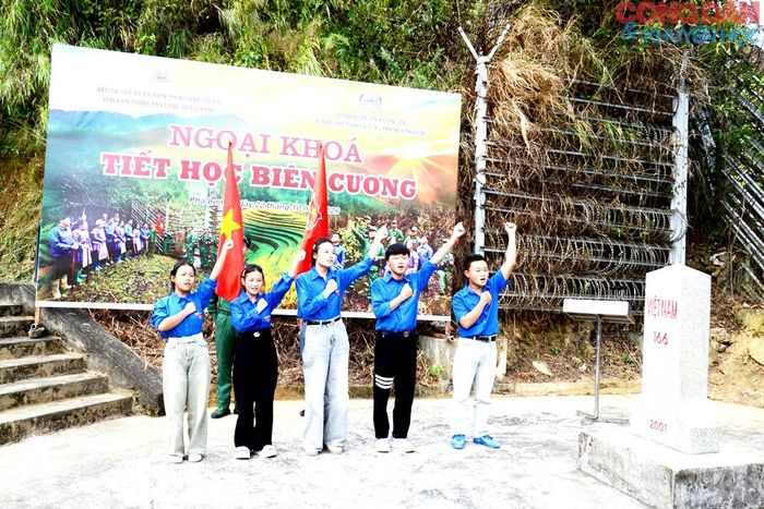 Các em học sinh được kết nạp vào Đoàn tuyên thệ bên cột mốc chủ quyền biên giới. Ảnh: Quốc Hồng