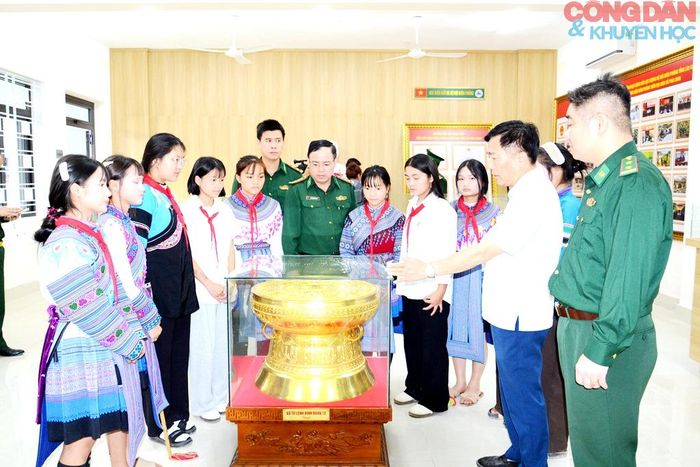 Các em học sinh tham quan phiên bản trống đồng được phát hiện tìm thấy tại xã Pha Long, hiện được trưng bày tại Phòng truyền thống của nhà trường. Ảnh: Quốc Hồng
