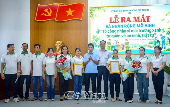 Phó Chủ tịch UBND phường Tân Thành Lâm Bảo Xuyên (bên phải) và Chủ tịch Hội đồng quản trị Công ty cổ phần Môi trường đô thị Cà Mau Dương Thành Nghĩa trao quyết định thành lập mô hình cho các thành viên.