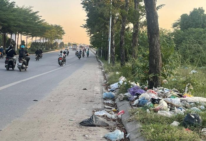 Rác thải chất thành đống ngay lối lên cầu vượt đường sắt hướng về khu đô thị Thanh Hà gây mất mỹ quan đô thị. Ảnh: PV