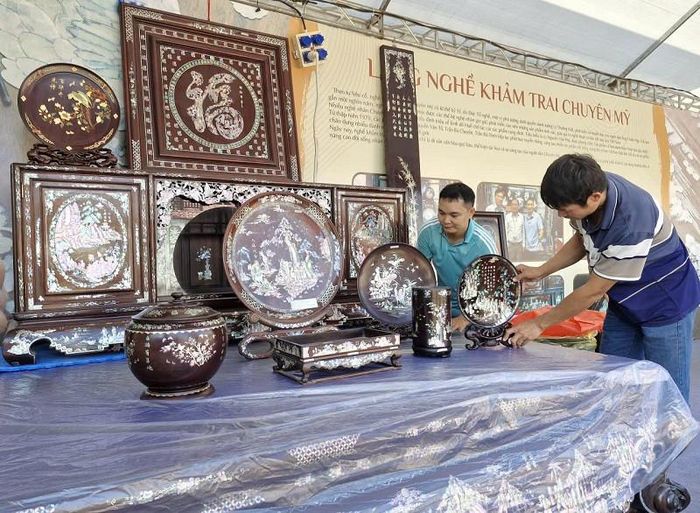 Anh Dương Xuân Hai tập trung trưng bày, giới thiệu sản phẩm đồ gỗ khảm trai, ốc tại Lễ hội vinh danh làng nghề và Tuần lễ quảng bá nông sản - đặc sản vùng miền Hà Nội năm 2026. Ảnh: PV