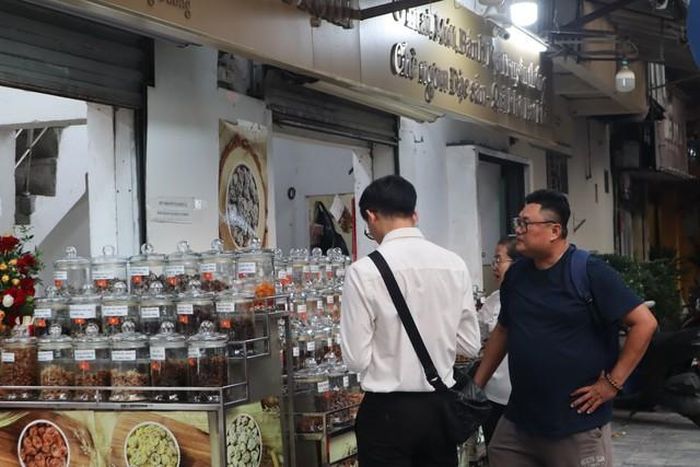 Khách dừng chân xem những lọ ô mai trưng bày sát mặt phố tại Tiến Thịnh. Ảnh: Linh Thảo