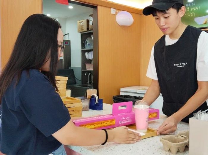Khách hàng mua combo bánh tart trứng siêu dài và đồ uống