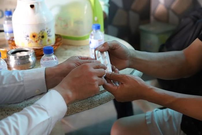 BS.CKII Nguyễn Quang Gấm – Giám đốc Trạm Y tế xã Hiệp Phước trao và hướng dẫn sử dụng thuốc kháng sinh cho gia đình bệnh nhi mắc não mô cầu. Ảnh: P.Thương.