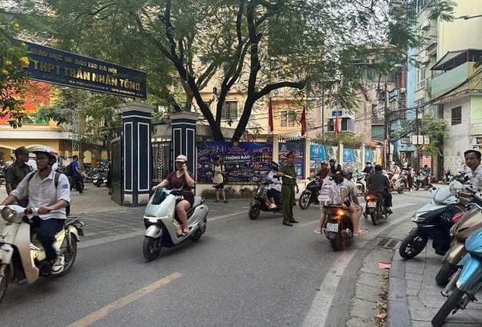 Học sinh, phụ huynh đỗ xe sát và trên hè nhường lòng đường cho các phương tiện lưu thông. Ảnh: A.M.