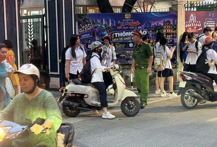 Công an luôn túc trực tại khu vực cổng trường giờ cao điểm. Ảnh: A.M.
