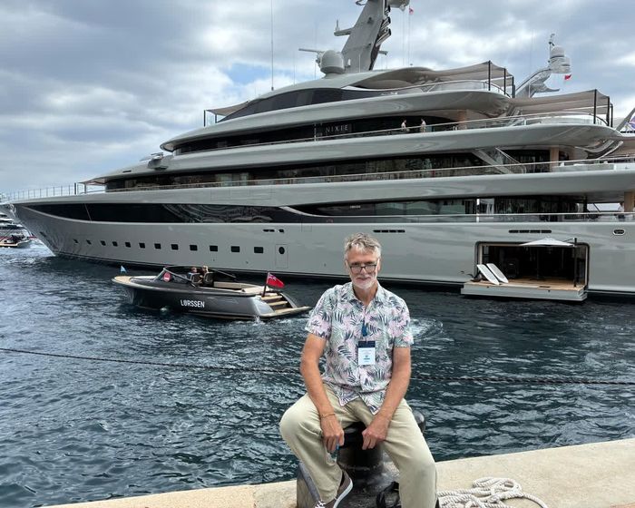  Sam Wollaston tại Triển lãm Du thuyền Monaco với siêu du thuyền Nixie dài 102 mét phía sau. Ảnh: Guardian. 