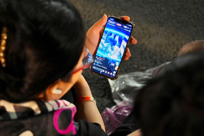  Một khán giả cùng bạn ngồi bên ngoài sân Mỹ Đình và theo dõi concert thông qua livestream. Chương trình mở màn bằng Fantastic Baby - bản hit phát hành năm 2012, từng đưa Big Bang trở thành nhóm nhạc Hàn Quốc đầu tiên có MV đạt 200 triệu lượt xem trên YouTube vào tháng 1/2016. 