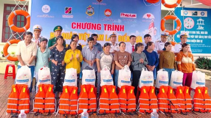 Đại diện các đơn vị trao quà tặng các gia đình ngư dân khó khăn. (Ảnh: NGUYỄN LÂN)