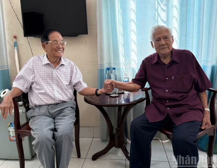 Anh hùng Hồ Đắc Thạnh (nguyên Thuyền trưởng Tàu 41) và cựu chiến binh Huỳnh Văn Tiến (Mười Tiến) ôn lại những kỷ niệm về Thủy thủ trưởng Trần Nhợ trong ngày người đồng đội năm xưa được vinh danh Anh hùng Lực lượng vũ trang nhân dân.