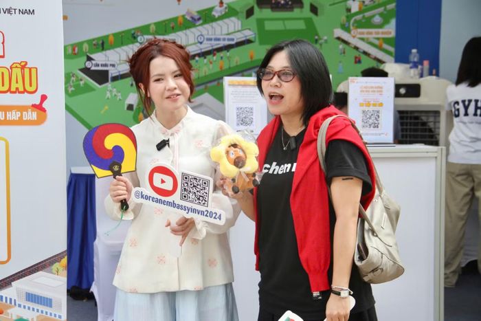 Đại diện gian hàng trao quà tặng lưu niệm cho khách tham quan.